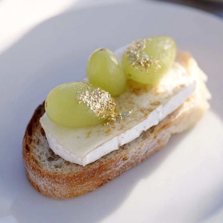 A beautiful close-up of Sparkling Champagne Toast: creamy cheese with glittering gold, ready to serve guests.