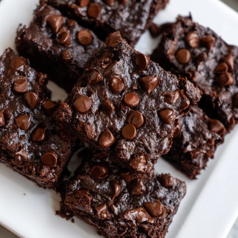 Square slices of Greek Yogurt Brownies, perfectly baked and waiting to be enjoyed with a scoop of yogurt.