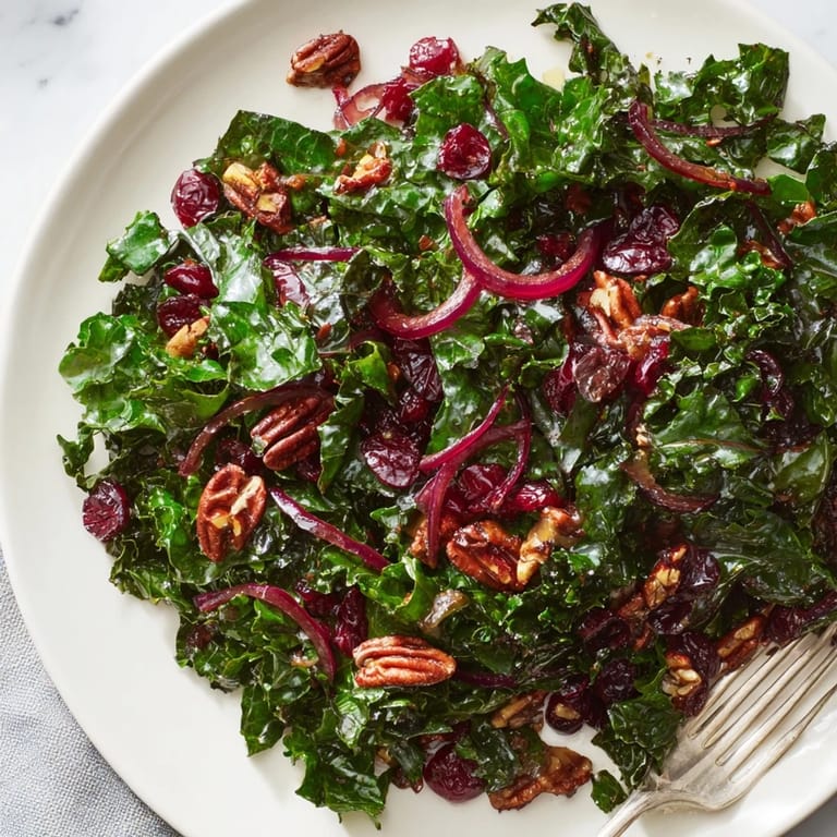 Easy vegetarian side dish featuring tender kale, dried cranberries, and toasted walnuts drizzled with warm maple mustard vinaigrette.