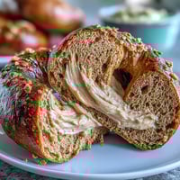 Golden whole wheat bagels with a chewy texture, sweetened with honey and enriched with protein, served with a creamy yogurt dip for a healthy breakfast.