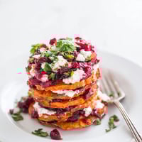 Layers of roasted sweet potato topped with zesty cranberry jalapeño dip and herbs.  